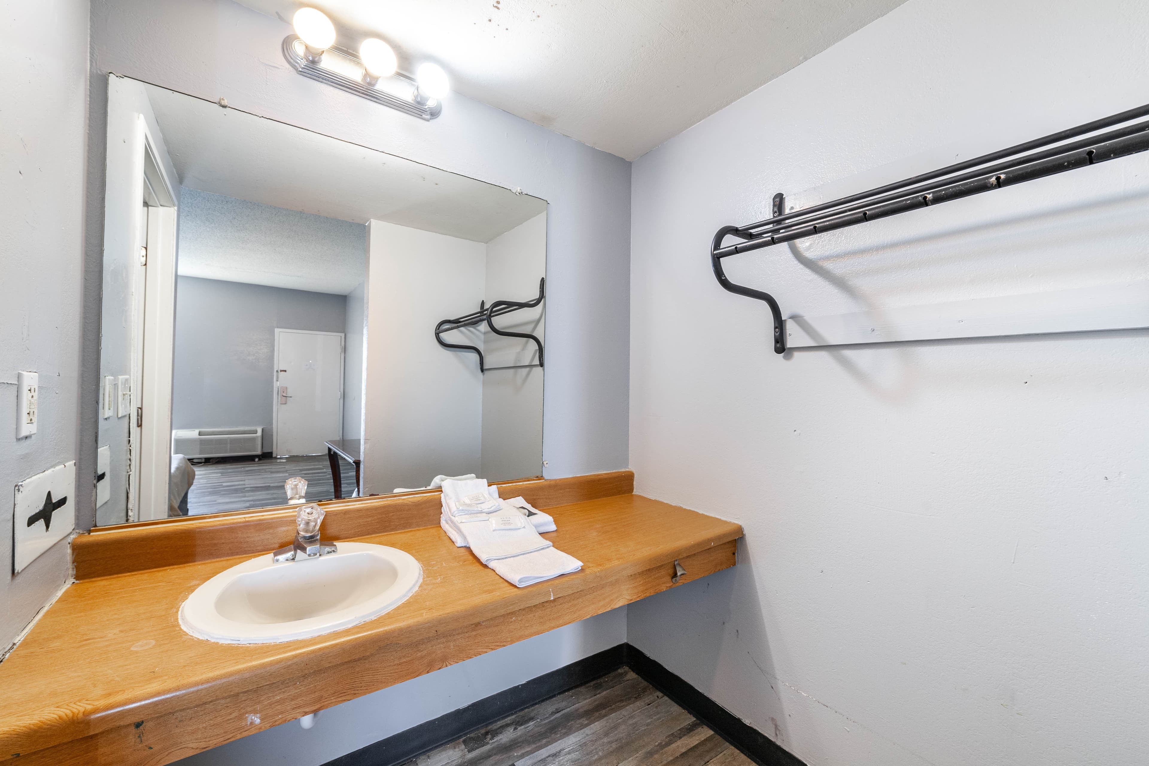 Guest bathroom vanity with sink, mirror, and fresh towels
